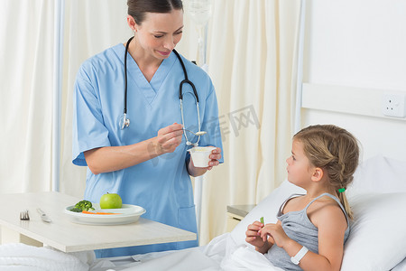 护理床摄影照片_医生给生病的女孩喂饭