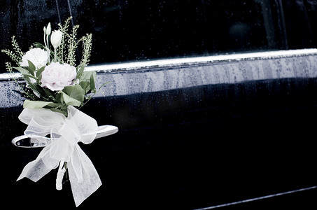 蝴蝶结绳子摄影照片_婚礼花边蝴蝶结和鲜花婚车门