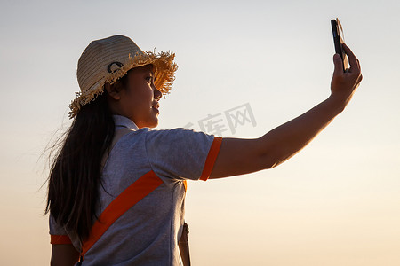 泰国女人摄影照片_泰国女人在海滩上使用智能手机