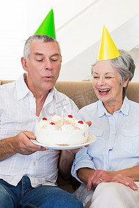 年长夫妇坐在沙发上庆祝生日