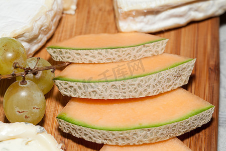 葡萄片摄影照片_奶酪配白葡萄和甜瓜。