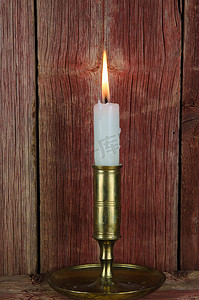 墙上的蜡烛摄影照片_旧墙上烛台上的单支蜡烛