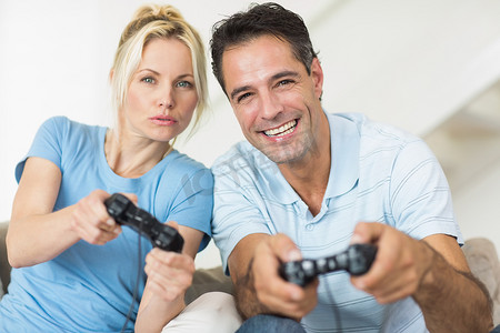 在客厅玩电子游戏的快乐夫妇