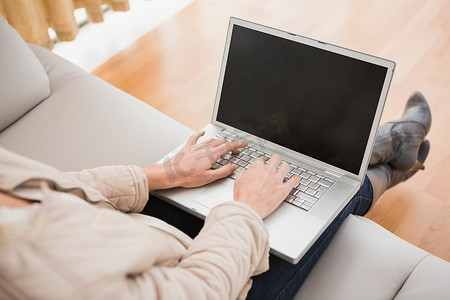 金发女人在沙发上使用笔记本电脑