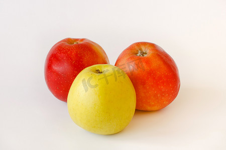 白色背景中的两个红色和一个绿色苹果
