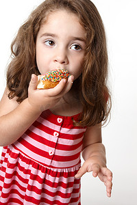 吃甜甜圈的俏丽的小女孩