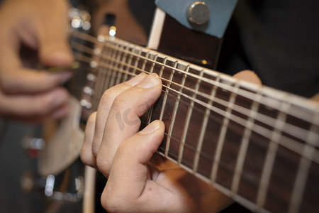 一个男人用手指放在吉他琴品上的特写镜头