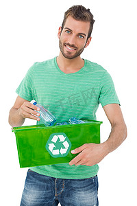 一个微笑的年轻人携带回收容器的肖像
