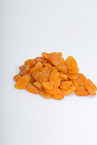 美食背景装饰摄影照片_白色背景中的一堆杏干