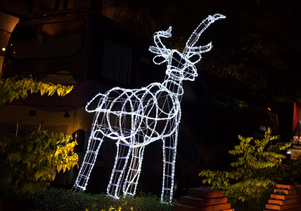 鹿黄色摄影照片_由电线和灯泡制成的发光驯鹿