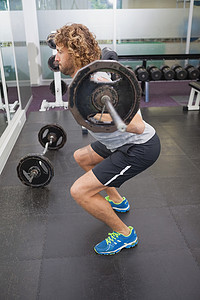 肌肉男成人摄影照片_肌肉男在健身房举杠铃的侧视图