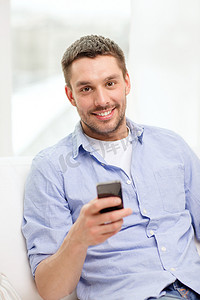 手机版电商首页摄影照片_家里有智能手机的微笑男人