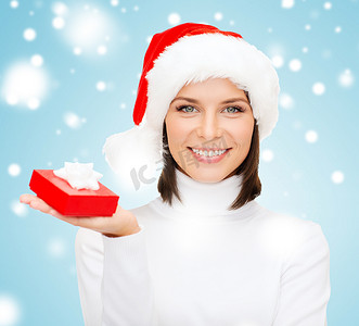 雪花圣诞帽摄影照片_戴着圣诞帽、带小礼盒的微笑女人