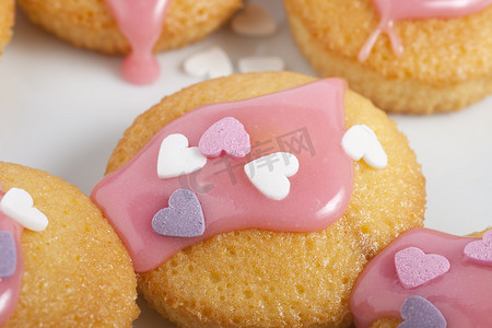 爱心粉红色摄影照片_带糖霜和爱心的纸杯蛋糕