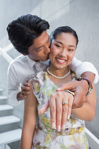 一对夫妇在女人的手指上展示订婚戒指