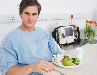 病房吃饭摄影照片_英俊的男人在医院吃饭