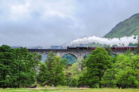 哈利波特旗子摄影照片_Glenfinnan 高架桥上的蒸汽火车，因哈利波特而闻名