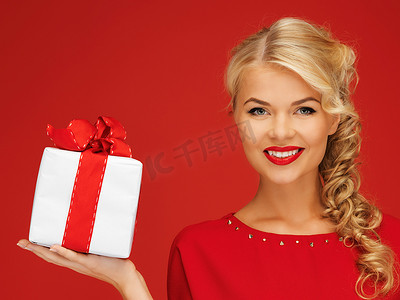 可爱礼物盒子摄影照片_有礼物的红色礼服的可爱的妇女