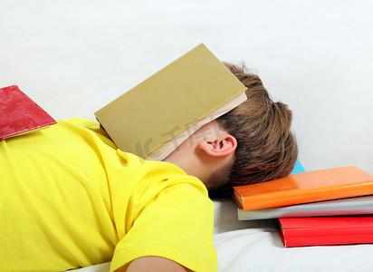 男性睡觉摄影照片_青少年带着书睡觉