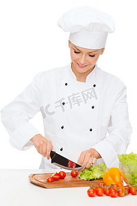 厨师女厨师摄影照片_微笑的女厨师切菜