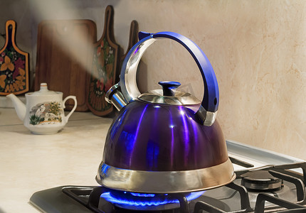 水茶摄影照片_在煤气炉的火焰上烧开水的水壶。