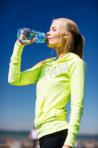妇女在户外运动后喝水