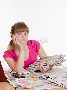 桌边放着一堆报纸的女孩