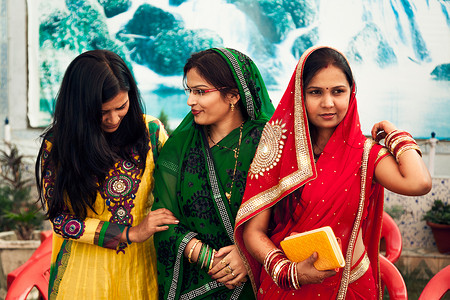 印度纱丽摄影照片_身穿彩色纱丽服的快乐印度女性