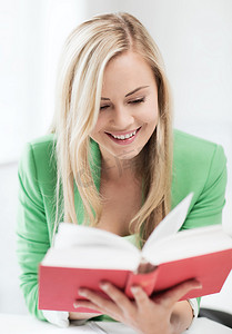 微笑的年轻女子在学校看书