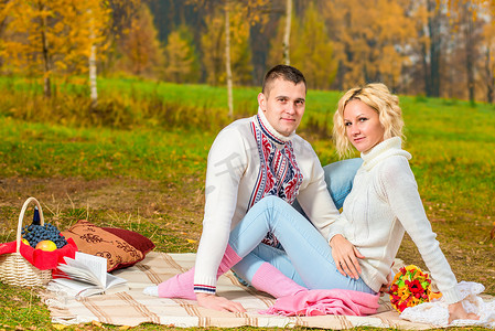 家庭野餐年轻夫妇在秋季公园的大自然