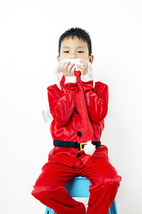 圣诞帽绿色摄影照片_白色背景中戴着红色圣诞帽的亚洲小男孩