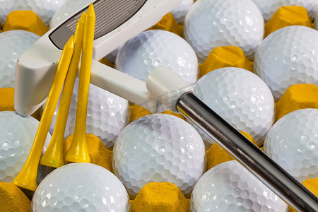 推杆摄影照片_黄色盒子里的白色高尔夫球和高尔夫球推杆