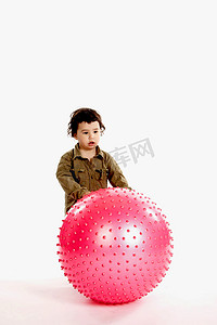 有一个大桃红色球的小男孩