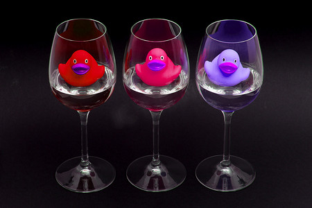 酒杯中的红色、粉色和紫色橡皮鸭