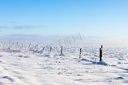 有积雪的地面的带刺铁丝网