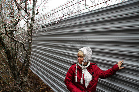 受保护摄影照片_生态学家 Evgenia Chirikova 靠近州长 Tkachyov 在受保护的树林中的小屋的围栏