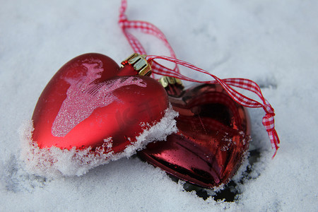雪心摄影照片_雪中​​的红白心形饰品