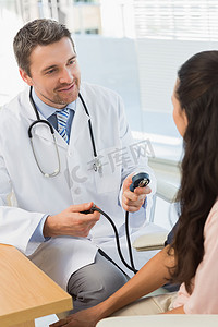 检查一名少妇的血压的男性医生