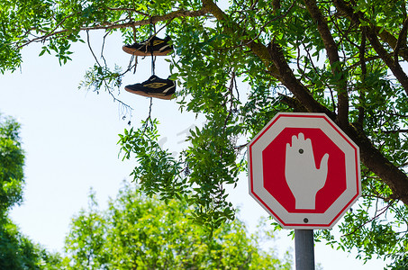 错误的标志摄影照片_错误的停车标志和鞋子在树上