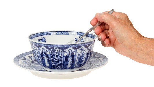 老太太（手）在一个古董荷兰汤碗里拿着勺子