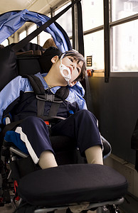 坐在轮椅上的残疾小男孩在校车上