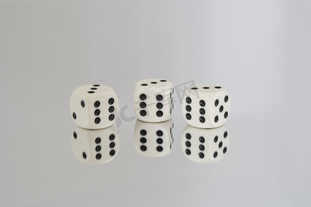骰子三个六摄影照片_三个带有黑色斑点和反射的白色骰子