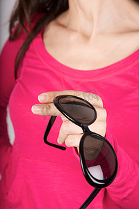 粉色毛衣背景上的黑色墨镜