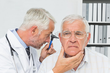 一名男性医生检查老年患者耳朵的特写镜头