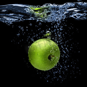 绿色苹果掉进水里，飞溅在黑色上