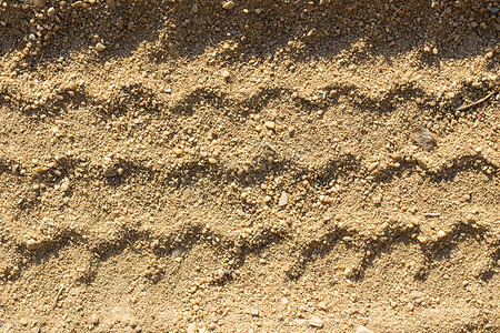 在沙子的汽车轮胎轨道，作为背景
