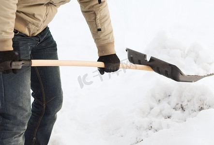 铲雪摄影照片_从车道上铲雪的人的特写