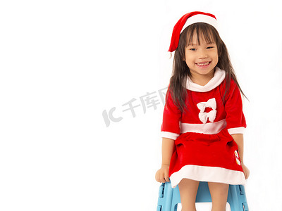 圣诞帽绿色摄影照片_白色背景中戴着红色圣诞帽的亚洲小女孩