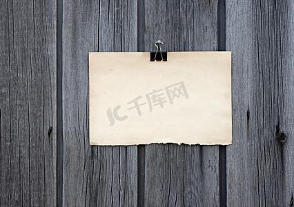 黑色夹子和旧空白便条纸挂在木板上