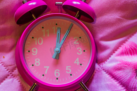 粉红色背景中粉红色复古闹钟的宏观特写